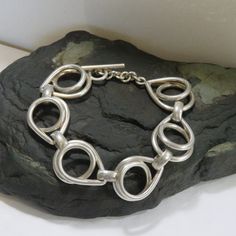 LARGE WRIST - This sterling bracelet measures 7 1/2 inches around the inside when closed. It is 22 mm wide. 59.6 grams sterling silver chain link bracelet, marked 925, vintage, toggle, large wrist. It is an unusual link and lays very nicely. It is marked 925, but I also used acid testing to determine that it is sterling silver. See pictures of the test. It turned a bright red which indicates sterling. Nickel would have turned dark green or black. Guaranteed sterling. PLEASE CHECK THAT IT WILL FIT BEFORE ORDERING.  Thank you.   For more sterling jewelry from MontanaPrairie, follow this link to my Etsy shop.  MontanaPrairie.etsy.com  All my jewelry is pre-owned, vintage or antique and MAY SHOW NORMAL WEAR.  It may (and probably will) need a little polishing to remove tarnish, but if there ar Modern Link Sterling Silver Bracelet With Toggle Clasp, Nickel-free Sterling Silver Chain Link Bracelet, Silver Chain Link Bracelet With Toggle Clasp, Everyday Silver Bracelet With Toggle Clasp, Vintage Sterling Silver Bracelets For Everyday, Vintage Sterling Silver Everyday Bracelets, Vintage Sterling Silver Everyday Bracelet, Modern Sterling Silver Bracelet With Toggle Clasp Gift, Sterling Silver Bracelet With Toggle Clasp For Formal Occasions