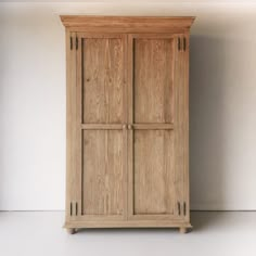 a tall wooden cabinet sitting on top of a white floor