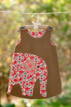 an elephant print dress hanging on a clothes line with green trees in the back ground