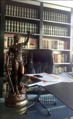 a desk with a statue and bookshelf in the background