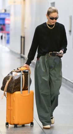 a woman walking down an airport with her luggage