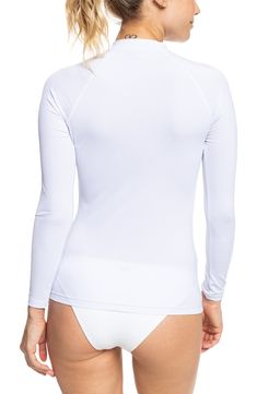 Spend a day in the waves wearing this protective rashguard styled with a high neckline and a sporty logo design. 24 1/2" length (size Medium)   Mock neck   Long sleeves   86% recycled polyester, 14% elastane   Hand wash, line dry   Imported Fitted White Tops With Thumbholes, Fitted White Top With Thumbholes, Upf 50+ Crew Neck Swimwear, Crew Neck Swimwear With Upf 50+, Sporty Elastane Swimwear For Surfing, Stretch Crew Neck Rash Guard For Surfing, White Upf 50+ Surfing Top, Long Sleeve Upf 50+ Swimwear For Athleisure, White Surfing Tops With Upf 50+