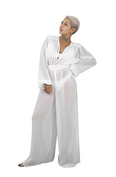 Tropic like it's hot in our Oasis Porcelain White Sheer Chiffon Jumpsuit. This long sleeve see through mesh jumpsuit makes the perfect resort attire or beach party outfit for a tropical vacation. FEATURES: Made with soft, breezy chiffon fabric Easy on and off with zipper and snap front Adjustable goatskin leather belt accentuates the waist Long princess style sleeves Full length wide leg Ethically made & 100% carbon neutral FIT NOTES:Fits true to size. Model is 5'4'' & wears size S. Also availab Resort Attire, Beach Party Outfit, Sheer Jumpsuit, Beach Party Outfits, Chiffon Jumpsuit, Mesh Jumpsuit, Beach Wear Outfits, Carbon Neutral, White Chiffon