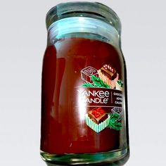 a jar filled with red liquid sitting on top of a table next to a white wall