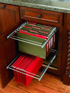 the drawers are full of files and folders in this kitchen cabinet door pullout