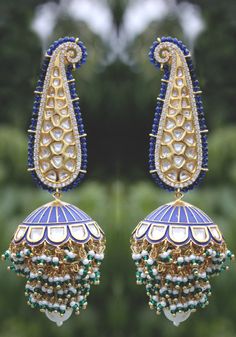 Blue enamel meenakari handpainted chandbaali featuring glass kundan work, cubic zirconia studs, pearl embellishments and plated with 22kt gold. These pretty earrings are a perfect match to all things pastels. The earring features pretty floral motif in glass kundan work and delicate cubic zirconia. The chandbali are embellished with high grade shell pearls. These earrings are handpainted by artisans of Kashmir who are famous for papier-mache artwork. Detailed hand painting alongside studded kund Blue Chandbali Jewelry With Cutdana, Blue Chandbali Jewelry With Cutdana Detail, Blue Temple Jewelry Jhumkas Gift, Blue Temple Jewelry Earrings For Diwali, Blue Cutdana Chandbali Jewelry, Blue Temple Jewelry Earrings For Festivals, Blue Chandbali Jhumkas With Latkans, Blue Tilla Jhumkas For Festivals, Blue Chandbali Jhumkas For Diwali