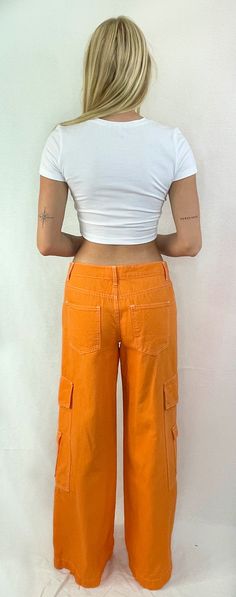 See things in color! These fun cotton cargo pants are the perfect trend in color. The flattering low-rise fit with wide legs and side snap pockets are just what you need to hit the streets. Pair this trend with a cute crop or your favorite tee and sneakers for a fun look. Color- Orange ( Also Available in Red) 100% Cotton Spring Cotton Cargo Pants With Cargo Pockets, Spring Cotton Cargo Pants With Multiple Pockets, Cotton Cargo Jeans For Spring, Spring Cotton Cargo Pants With Side Pockets, Spring Cotton Cargo Style Bottoms, Spring Cotton Cargo Bottoms, Spring Cotton Cargo-style Bottoms, Cropped Cotton Bottoms With Pockets, Trendy Relaxed Fit Cotton Cargo Pants