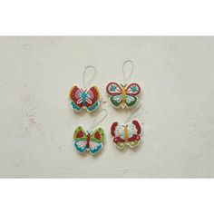 three colorful butterfly ornaments hanging on a wall