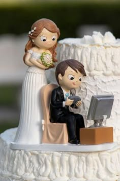 a wedding cake topper with a bride and groom on the computer at their desk