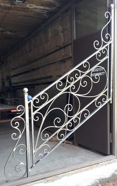 an iron stair railing in front of a door with a sign on it that says,