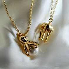 Dive into whimsy with this enchanting gold-plated necklace set. Featuring a quirky octopus pendant cradling a luminous shell pearl and a hollow jellyfish design, these unique pieces add a playful touch to any outfit. Perfect for ocean lovers and those who adore statement jewelry, this set is a delightful blend of elegance and fun. Pearls, known for their timeless beauty and elegance, are the perfect birthstone for June. Symbolizing purity, wisdom, and serenity, pearls add a touch of sophisticati Adjustable Clavicle Chain Jewelry For Gift, Adjustable Collar Necklace Jewelry As Gift, Adjustable Clavicle Chain Jewelry As A Gift, Party Charm Pendant Necklace With Lobster Clasp, Party Pendant Charm Necklace With Lobster Clasp, Sterling Silver Charms Jewelry For Party, Adjustable Gold Charm Necklaces For Party, Adjustable Gold Charm Necklace For Party, Adjustable Whimsical Jewelry For Gifts