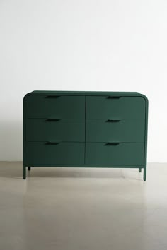 a green dresser sitting on top of a white floor