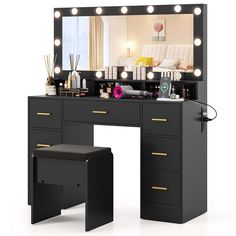 a black vanity with lights on it and a stool