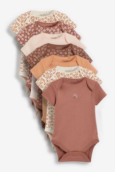 baby's bodysuits are lined up in different colors and patterns, including one with