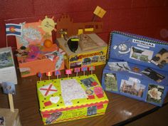 there are several boxes on the table with flags and pictures attached to them, all decorated in different colors