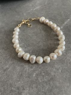 Handcrafted by IJ Design Boutique Made in Uk Made of: * Genuine Baroque pearls 9-10 mm * 18k gold plated details Bracelet circumference adjustable 16.5cm - 20cm / 6.5-7.9 Inches  Closure: Lobster clasps  -IJ DESIGN BOUTIQUE- From necklaces to earrings, we make jewellery using a wide range of materials. From silver and gold plated to freshwater pearls and real gemstones.  Our collections are all based on the latest trends in jewellery along with classic pieces which won't date. You are able to la Elegant Baroque Pearl Beaded Bracelets As Gifts, Luxury White Baroque Pearl Bracelets, Classic Baroque Pearl Bracelet For Formal Occasions, Classic Baroque Pearl Bracelets With Oyster Detail, Classic Baroque Pearl Bracelets With Oyster Clasp, Classic Baroque Pearl Bracelets, Handmade Luxury Pearl Bracelet, Luxury Baroque Pearl Bracelet In Pearl White, Handmade Luxury White Pearl Bracelet