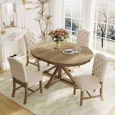 a dinning room table with chairs around it in front of a fireplace and large windows