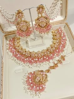 a jewelry set in a box with pearls and pink beads on the necklace, earrings and bracelet