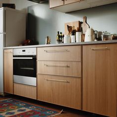 a kitchen with an oven, refrigerator and counter top in the middle of it's wooden cabinetry