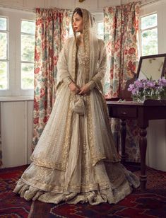 Premium Embellished Double Layered Traditional Pishwas Frock and Dupatta in Ivory Color Eid Wedding Dress With Sheer Dupatta, Eid Ceremony Wedding Dress With Sheer Dupatta, Elegant Wedding Sherwani With Sheer Dupatta, Bollywood Style Cream Dress With Sheer Dupatta, Beige Zari Wedding Dress, Beige Zari Work Wedding Dress, Off White Raw Silk Anarkali Dress, Off White Anarkali Dress In Raw Silk, Beige Wedding Dress With Zari Work