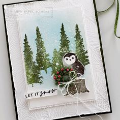 a close up of a card with an owl on it and trees in the background