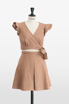 Discover timeless elegance with our brown ruffle sleeve crop top and matching pleated skirt set, a testament to the beauty of artisanal craftsmanship. 🌟 This set exudes sophistication with a crop top that features delicate ruffle sleeves and a charming tie closure, enhancing your waistline with its feminine design. The coordinating skirt is masterfully pleated both front and back, providing a graceful flow and a flattering fit for all figures. Meticulously constructed with superior fabric quali Chic Pleated Skirt Sets For Spring, Chic Spring Sets With Pleated Skirt, Summer Workwear Sets In Brown, Chic Pleated Spring Sets, Summer Sets With Ruffle Hem And Fitted Design, Summer Sets With Fitted Ruffle Hem, Fitted Beige Sets With Ruffles, Elegant Brown Sets For Spring, Skater Style