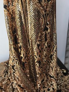 Stunning piece of embroidery, thousands of orangy gold sequins embroidered on black tulle to form this intricate design. This fabric is suitable for a stunning outfit to impress. Width is 140cm. Price is for one meter. Orders over one meter will be a continuous length of fabric. Gold Lace Sequin Fabric With Lace Work, Elegant Black Lace Sequin Fabric, Metallic Sequin Fabric For Festive Occasions, Glamorous Sequined Embroidered Fabric For Party, Gold Sequin Lace With Intricate Embroidery, Elegant Metallic Sequin Fabric For Festive Occasions, Black Glamorous Sequin Fabric For Festive Occasions, Party Lace Embroidered Fabric, Glamorous Black Sequin Fabric For Festive Occasions