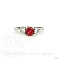 a white gold ring with a red stone and three diamonds