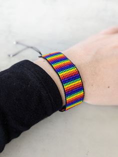 Show your pride or celebrate your loved ones with this rainbow bead bracelet. Hand loomed with glass beads and waxed cotton cord, this accessory is durable enough for daily wear, not just pride month. The band measures 1" wide by 5" long, but is adjustable to fit a 5" to 9 1/2" inch wrist with a sliding knot closure. Interested in a different design, color or size? Let me know with a private message! Rainbow Adjustable Cord Jewelry For Festivals, Rainbow Festival Jewelry With Adjustable Cord, Rainbow Jewelry With Adjustable Cord For Festivals, Rainbow Jewelry With Adjustable Cord, Rainbow Adjustable Cord Jewelry, Multicolor Friendship Bracelets With Round Beads And Adjustable Cord, Rainbow Sliding Knot Bracelets For Friendship, Rainbow Sliding Knot Bracelet For Friendship, Casual Rainbow Beaded Bracelets With Sliding Knot