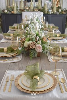 the table is set with green napkins and gold place settings