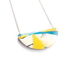 A vibrant and joyful semi circular necklace, combining streams of different coloured acrylic to create an abstract and colourful design. Created by encasing white, blue and yellow acrylic within layers of high gloss resin and then sanding and polishing by hand. The necklace is lovely and light weight and easy to wear.  The back of this necklace is similarly unique and is streaked with different shades of green. The pendant is 60mm wide, 25mm high and paired with an 18inch sterling silver chain. Hand Embroidered Necklace, Abstract Necklace, Poppy Necklace, Abstract Pendant, Rectangle Necklace, Colourful Design, Christmas Gifts For Girlfriend, Different Shades Of Green, Statement Choker Necklace