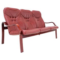 a red leather couch sitting on top of a wooden frame