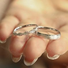 two white gold wedding rings with diamonds on their fingers