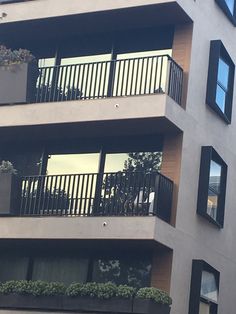 an apartment building with balconies and plants on the balconies are shown