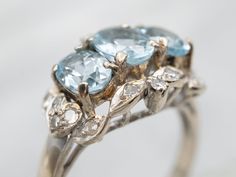 Treat yourself to something special with this dazzling ring! Show off your unique style with the glimmering white gold and aquamarine stones, sparkled with diamond accents. The perfect statement piece to let everyone know you mean business.Metal: 10K White GoldGem: 3 Aquamarine totaling 1.36 CaratsGem Measurements: 4.7 x 6.2 mm, OvalAccents: 16 Single Cut Diamonds totaling .22 Carats, SI in Clarity, G-H in ColorRing Size: 6.25Marks: "10K" Stamped on the inside band White Gold Aquamarine Ring, Gold Aquamarine Ring, Pocket Watch Chain, Ring With Diamond, Aquamarine Ring, Aquamarine Stone, Aquamarine Rings, Watch Chain, Glass Pieces