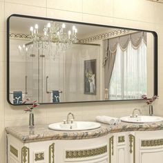 a bathroom with two sinks and a large mirror on the wall over it's counter