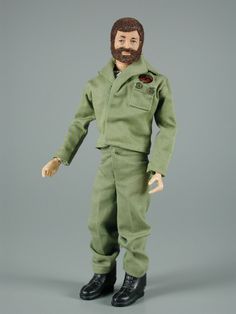 the action figure is wearing an army uniform and holding his hand out to someone's face