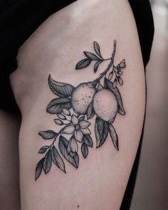 a woman's thigh with fruit and leaves tattoo on her side ribcage