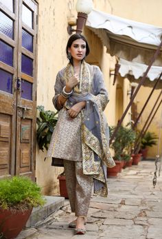 The set consists of straight cut handwork printed kurta with gota detailing, 3/4th sleeves, round neck, knee length teamed with printed trouser and a dupatta with border. Suit Fabric-Georgette Dupatta Fabric-Organza Kurta length - 40 in Pants length - 38 in Model is wearing size small. She is 5.8” tall. Washing Care-Dry Clean Organza Kurta, Georgette Dupatta, Grey Suit, Suit Fabric, Gray Suit, Suit Set, Pants Length, Raw Silk, Straight Cut