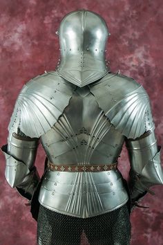 a knight's armor is displayed in front of a red background