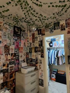 a room that has many pictures on the wall and clothes hanging up in the closet