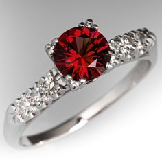 a red diamond ring with white diamonds around it