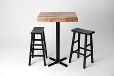 two stools and a table with a wooden top on a white background in front of it