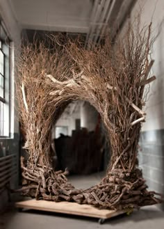 a wreath made out of branches sitting on top of a wooden pallet