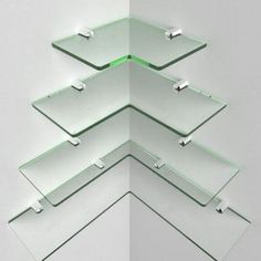 four glass shelves stacked on top of each other in the shape of a christmas tree