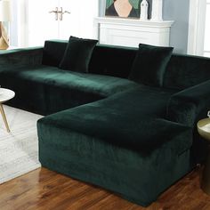 a large green couch sitting in a living room next to a white table and lamp