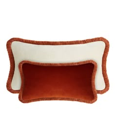 two orange and white pillows on top of each other