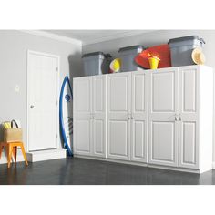 a room with white cabinets and surfboards on the wall