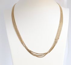 The elegant gold layered necklace boasts a sophisticated design with beaded sections on both sides, adding a touch of refinement and charm. Its multi-layered structure creates a statement piece that gracefully enhances any neckline, making it a versatile and eye-catching addition to your jewelry collection. Elegant Yellow Gold Multi-strand Jewelry, Elegant Multi-strand Yellow Gold Jewelry, Elegant Gold-plated Beaded Necklaces, Elegant Multi-strand Delicate Chain Jewelry, Gold-tone Multi-strand Necklaces For Layering, Elegant Gold Multi-strand Necklace, Elegant Multi-strand Gold Necklace, Elegant Multi-strand Necklace With Delicate Chain, Elegant Double Strand Gold Plated Necklace