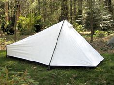 a white tent sitting on top of a lush green field